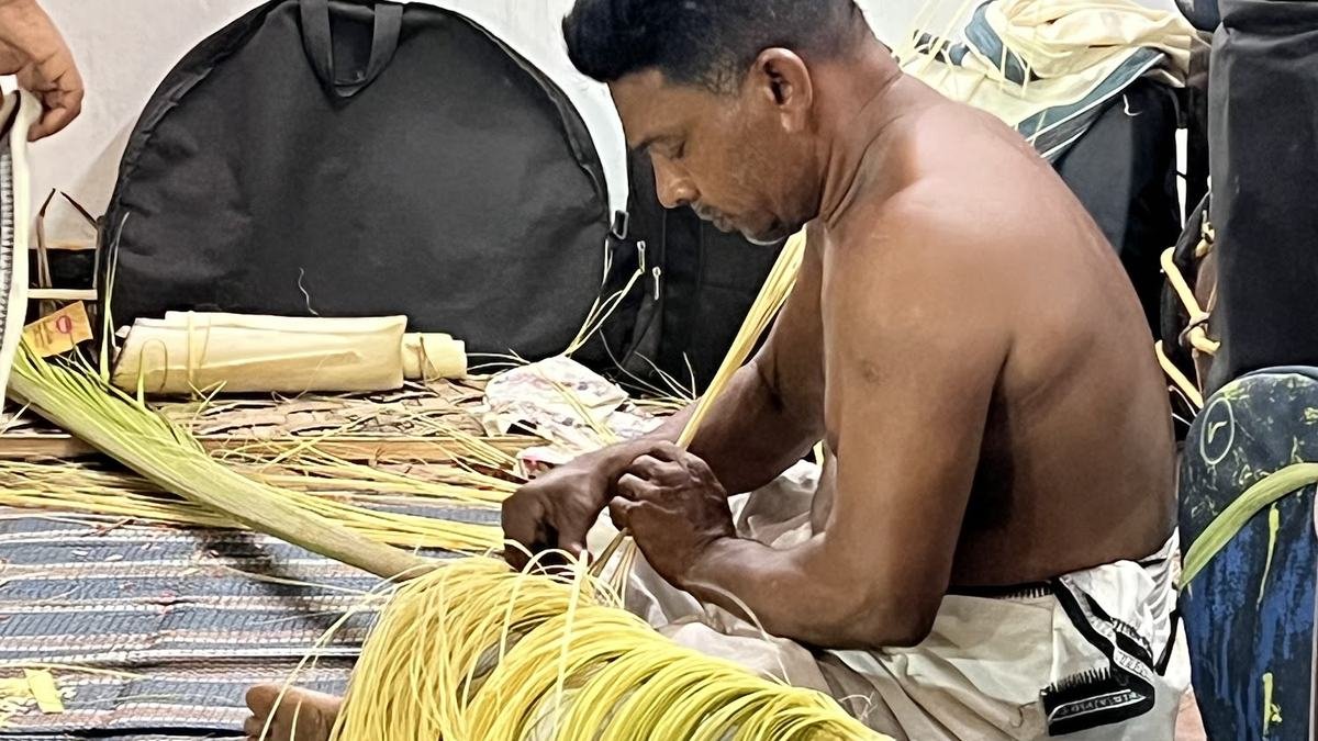A craftsman weaving yellow palm fibre for Theyyam attire