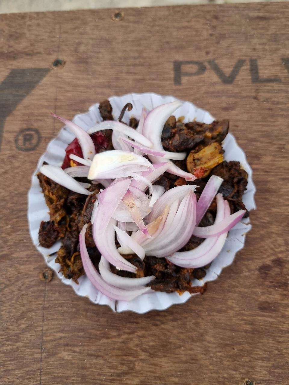 A small plate of fried mussels topped with sliced onion