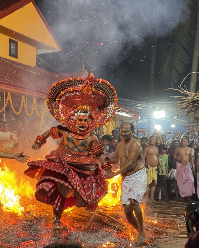 Kandanar Kelan Theyyam leaping across the fire at a shrine in Kannur