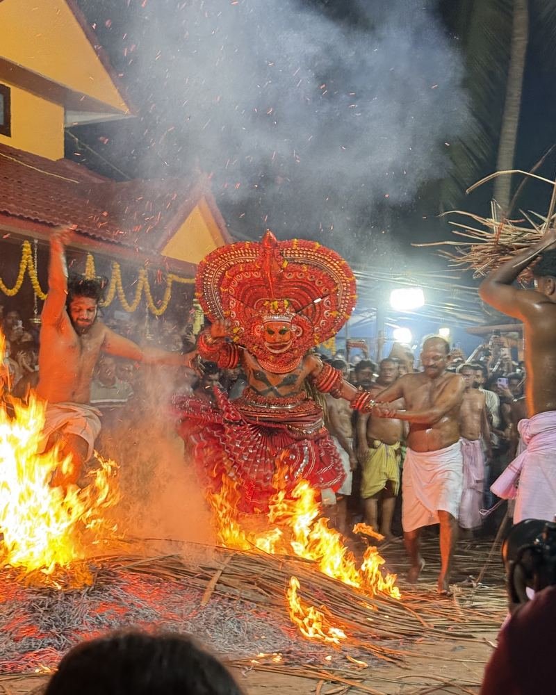 The Kandanar Kelan ritual: the Theyyam crosses the burning pit with devotees close by