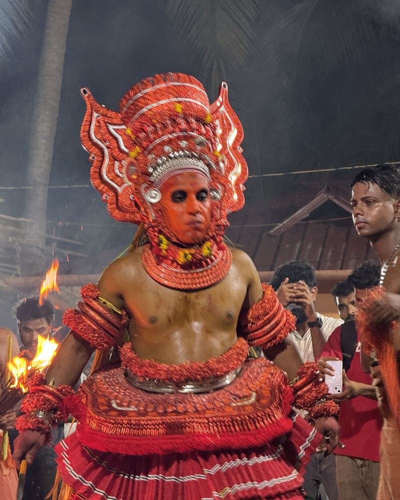 Portrait of a Theyyam in a red headdress during the ritual