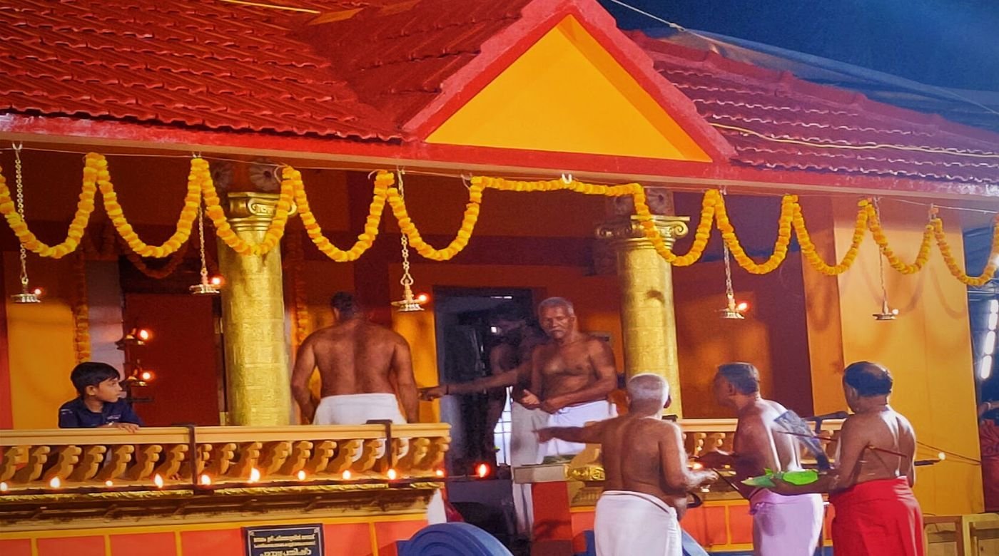 A North Malabar shrine at night, decorated with marigold garlands and lamps